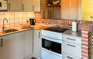a kitchen with white cabinets and a stove top oven at Beach Front Home In Ringkøbing With Sauna in Ringkøbing