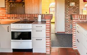 a kitchen with white appliances and a brick wall at Beach Front Home In Ringkøbing With Sauna in Ringkøbing +11 photos
