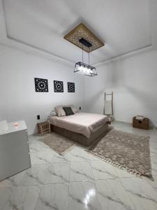 ein Schlafzimmer mit einem Bett in einem weißen Zimmer in der Unterkunft Dar Timi in Ech Chaïbat + 13 Fotos