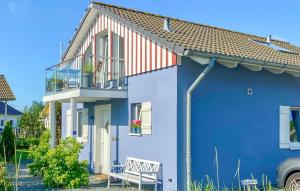 a blue house with a bench in front of it at Seebrise B in Süssau
