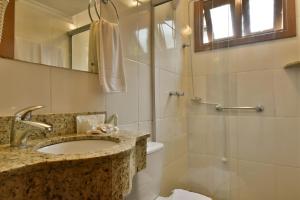 a bathroom with a sink and a shower at Pousada Stillo Gramado Centro - 300 metros da rua coberta in Gramado +65 photos