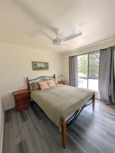 a bedroom with a bed and a ceiling fan at Green Acres in Gympie in Monkland
