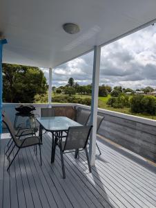 a patio with a table and chairs on a deck at Green Acres in Gympie in Monkland