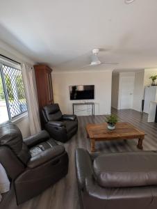 a living room with a couch and a table at Green Acres in Gympie in Monkland