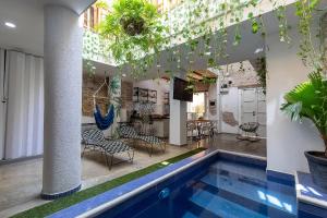 a pool in a building with chairs and a table at House with Private Pool & Rooftop in Cartagena de Indias