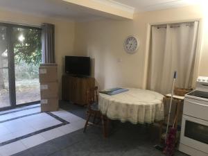 a kitchen with a table and a clock on the wall at The Mango Tree in Fingal Bay