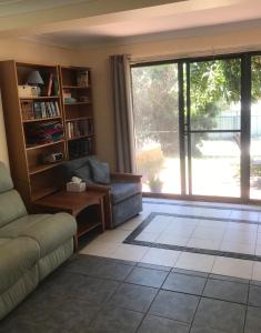 a living room with a couch and a large window at The Mango Tree in Fingal Bay