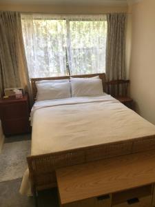a large bed in a room with a window at The Mango Tree in Fingal Bay