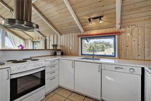 a kitchen with white cabinets and a sink and a stove at SL117-Slagelse-Egebaekvej-6 in Slagelse