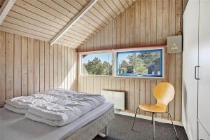 a bedroom with a bed and a chair and a window at SL117-Slagelse-Egebaekvej-6 in Slagelse