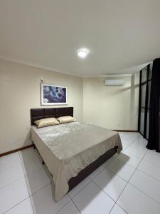 a bedroom with a large bed in a white room at Apartamento moderno - Amazonas Flat in Manaus