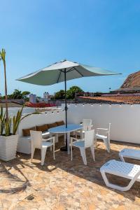 a table and chairs and an umbrella on a patio at House with Private Pool & Rooftop in Cartagena de Indias