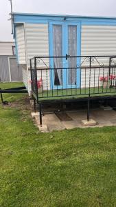 a green bench in front of a house at 137 sealands, 3 bed, 8 berth caravan hire, ingoldmells, skegness recently modernised in Ingoldmells