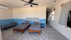 a room with two beds and a ceiling fan at Casa Laura Penthouse in El Cuyo