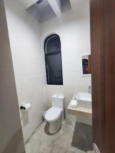 a white bathroom with a toilet and a sink at Casa Laura Penthouse in El Cuyo +25 photos
