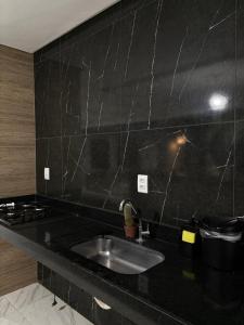 a kitchen with a sink and a black counter top at Green House in Juazeiro do Norte