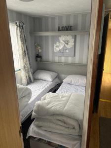a room with two beds and a sign that says love at 137 sealands, 3 bed, 8 berth caravan hire, ingoldmells, skegness recently modernised in Ingoldmells