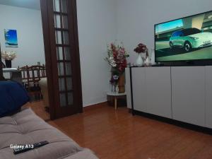 a living room with a tv and a couch at Próximo ao centro de Mariana MG in Mariana