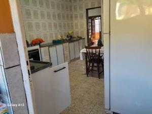a kitchen with a white refrigerator and a table at Próximo ao centro de Mariana MG in Mariana