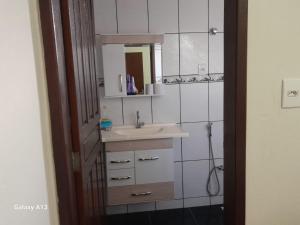 a bathroom with a sink and a mirror at Próximo ao centro de Mariana MG in Mariana +17 photos