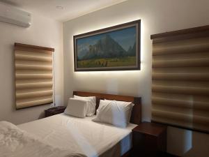 a bedroom with a bed and a painting on the wall at Oasis VangVieng Resort & Cafe in Ban Naka +52 photos