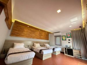 a bedroom with two beds and a television in it at Oasis VangVieng Resort & Cafe in Ban Naka
