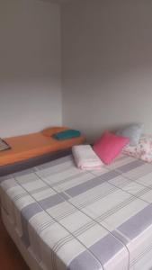 a bed with two pillows on it in a room at Próximo ao centro de Mariana MG in Mariana