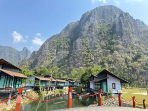 a mountain with a row of houses in front at Oasis VangVieng Resort & Cafe in Ban Naka