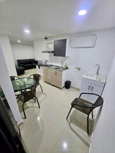 a kitchen and a living room with a table and chairs at Raíz Serena in El Retiro