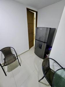 a room with two chairs and a refrigerator at Raíz Serena in El Retiro +5 photos