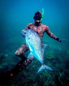 a person is holding a fish in the water at Daumi House in Masbagik