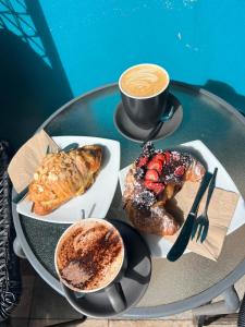 a table with two plates of pastries and a cup of coffee at Holiday house in Nelson Bay +21 photos
