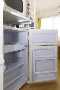 an empty refrigerator with its door open in a kitchen at アンドステイ屋形町306 in Kyoto