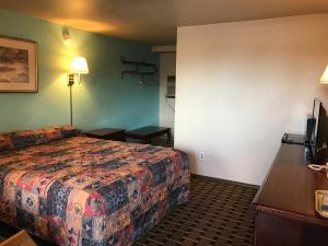 um quarto de hotel com uma cama e uma secretária em HWY Express Inn & Suites em Stillwater