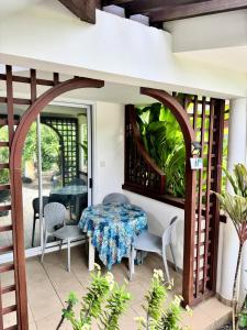 a room with a table and chairs on a patio at Relais Fenua in Punaauia
