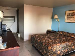 a hotel room with a bed and a table at HWY Express Inn & Suites in Stillwater