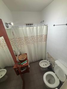 a bathroom with two toilets and a shower and a sink at Barrio La Victoria in Ezeiza +11 photos