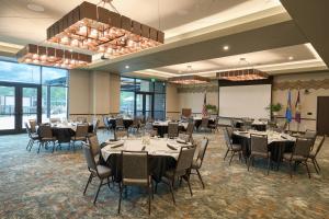 a conference room with tables and chairs and a projection screen at Choctaw Landing Casino & Resort, Trademark Coll by Wyndham in Broken Bow