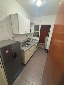 a small kitchen with a sink and a refrigerator at Barrio La Victoria in Ezeiza