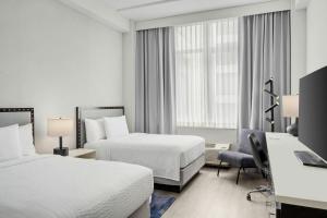 a hotel room with two beds and a desk at Fairfield Inn and Suites Chicago Downtown/ Magnificent Mile in Chicago +32 photos