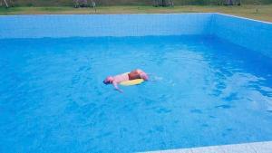 a person floating in a pool with a surfboard at Bàu Trắng Garden in Ấp Nhơn Hòa +33 photos