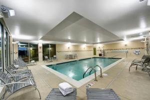 a pool in a hotel with chairs at TownePlace Suites by Marriott Providence North Kingstown in North Kingstown