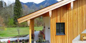 a yellow building with a porch with a window at Alpenchalet-Chiemgau in Marquartstein