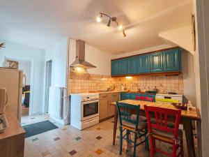 a kitchen with green cabinets and a table and chairs at Maison avec parking - 7 pers. - FR-1-591-784 in Éguzon-Chantôme +11 photos