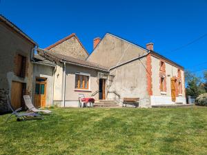 a house with a yard with chairs and a bench at Maison avec parking - 7 pers. - FR-1-591-784 in Éguzon-Chantôme