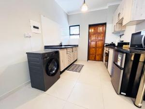 a kitchen with a washer and dryer in it at The Exec Place Maun in Maun