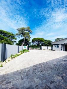 a brick driveway in front of a white building at The Exec Place Maun in Maun