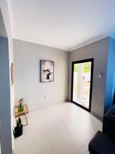 a living room with a large window and white walls at The Exec Place Maun in Maun