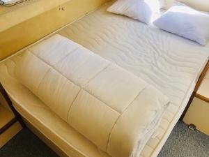 a bed with white sheets and pillows on it at Bateau sécurisé à quai - 6 pers. - API-1-46-30 in Colombiers