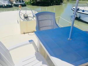 a table and chair on a boat in the water at Bateau sécurisé à quai - 6 pers. - API-1-46-30 in Colombiers